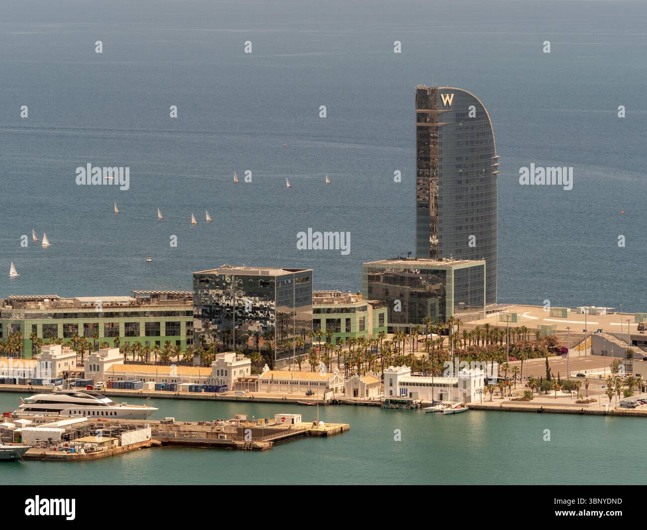 Teleobiettivo dell'iconico W Hotel a forma di vela sul lungomare di Barcellona, Spagna, con barche a vela sul Mar Mediterraneo. Foto Stock