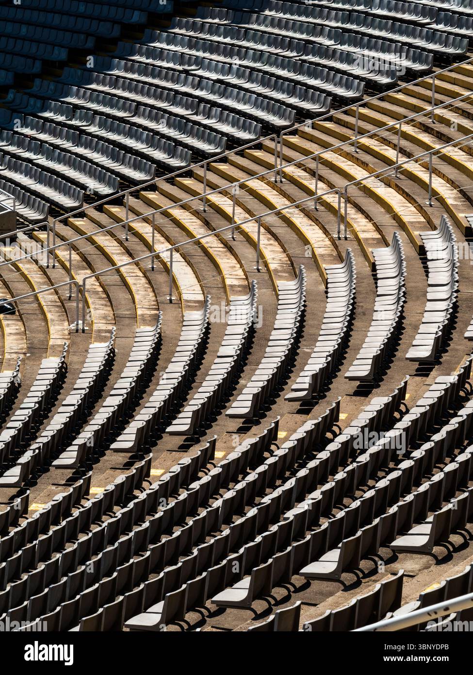 File curve di posti vuoti creano linee astratte e motivi all'interno dello storico Stadio Olimpico 1992 di Barcellona, Spagna. Foto Stock