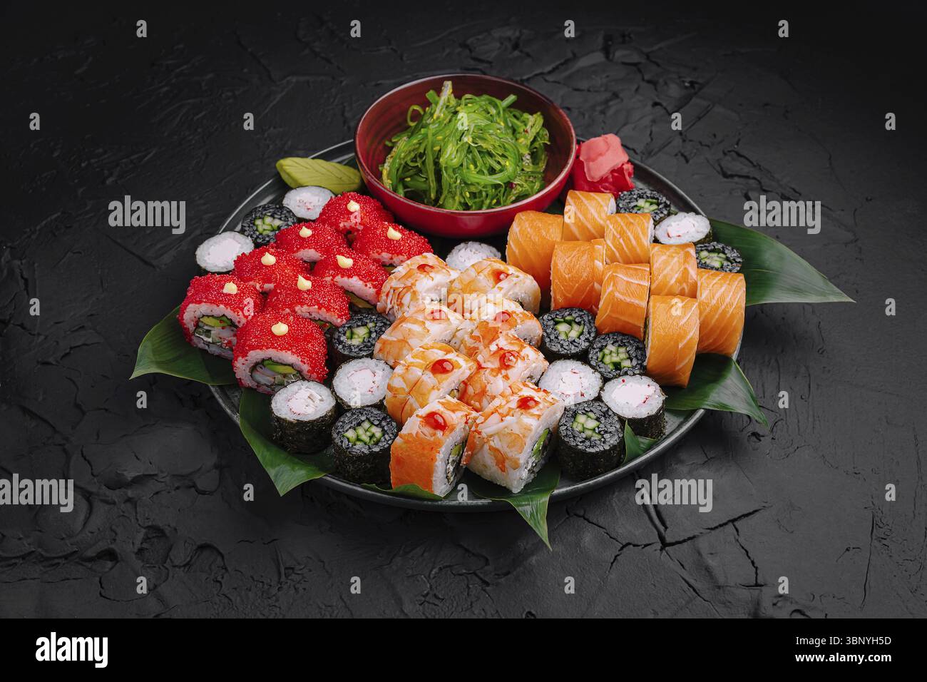 Food STILL-Life, Un piatto di sushi splendidamente organizzato presenta una varietà di sushi roll, tra cui coloratissimi maki e nigiri, ornati con alghe Foto Stock