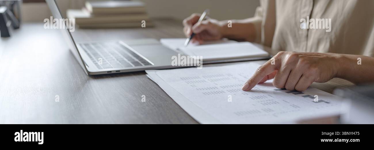 Immagine di donna calcolare la fattura fiscale a casa, riassumendo le tasse, planando il denaro Foto Stock