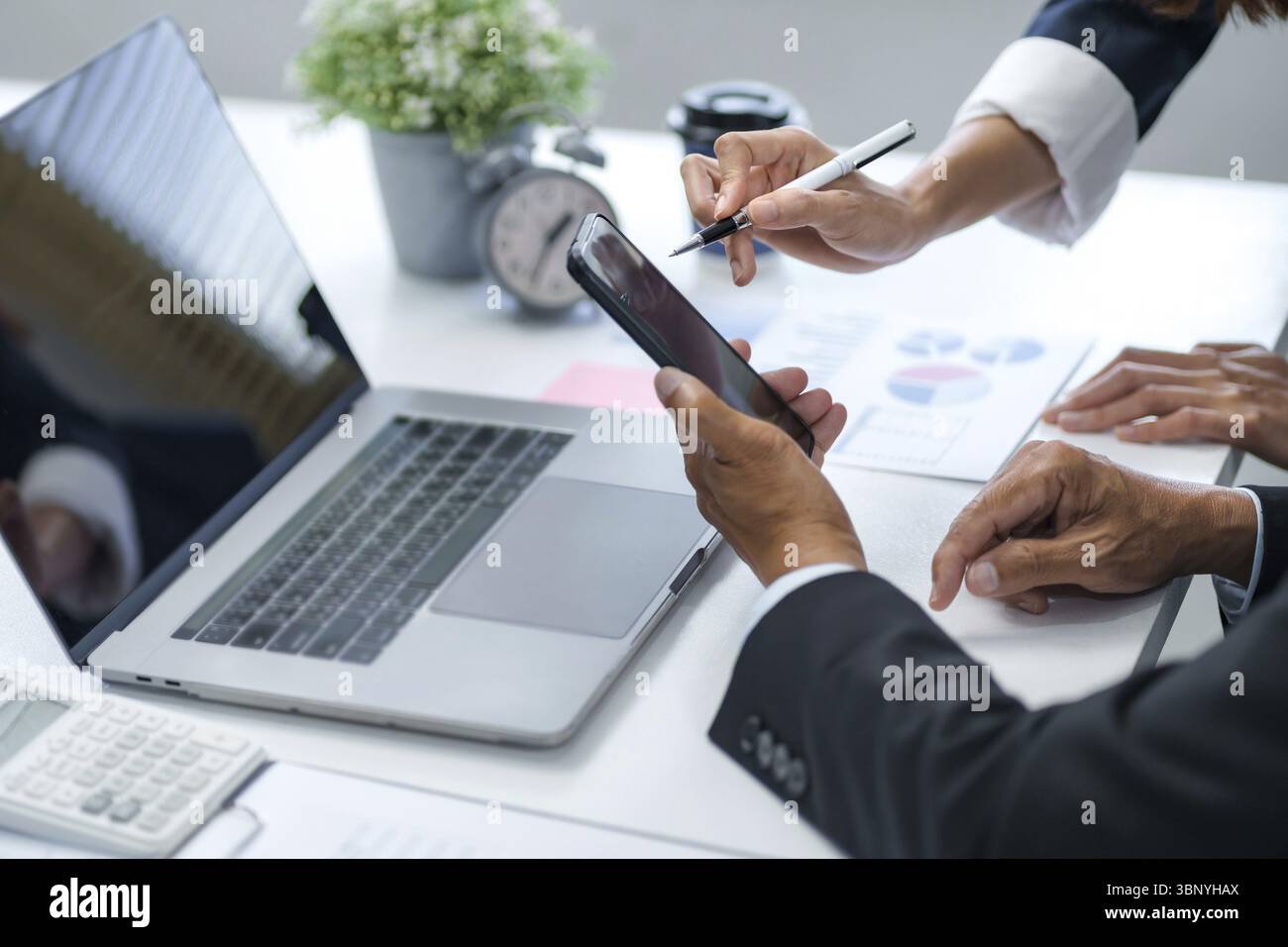 Analista aziendale che calcola i dati relativi al fatturato in ufficio Foto Stock