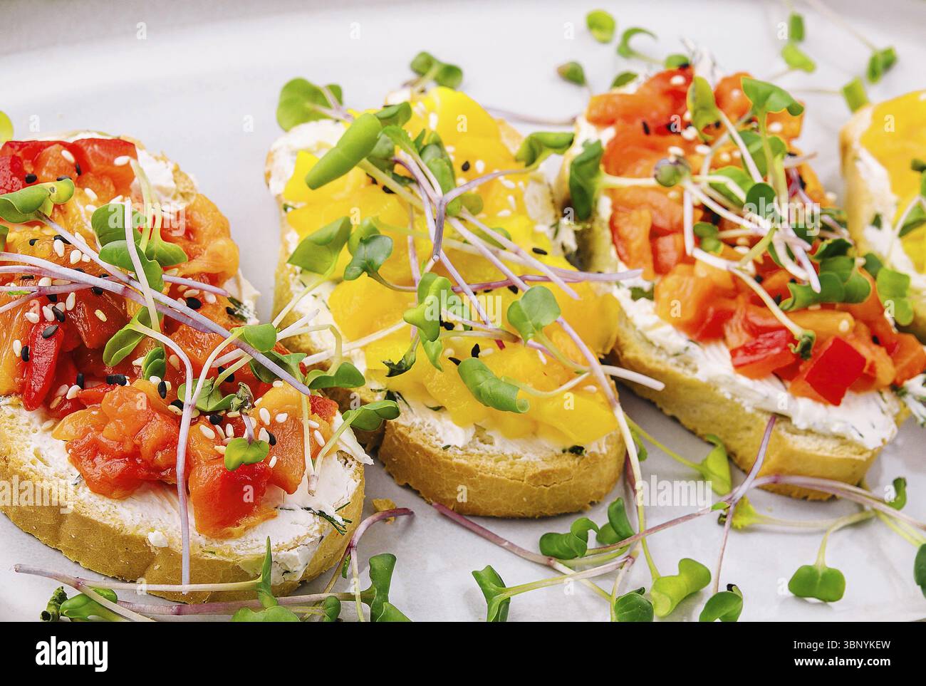 Natura morta, bruschetta con formaggio spalmabile e peperone grigliato multicolore Foto Stock