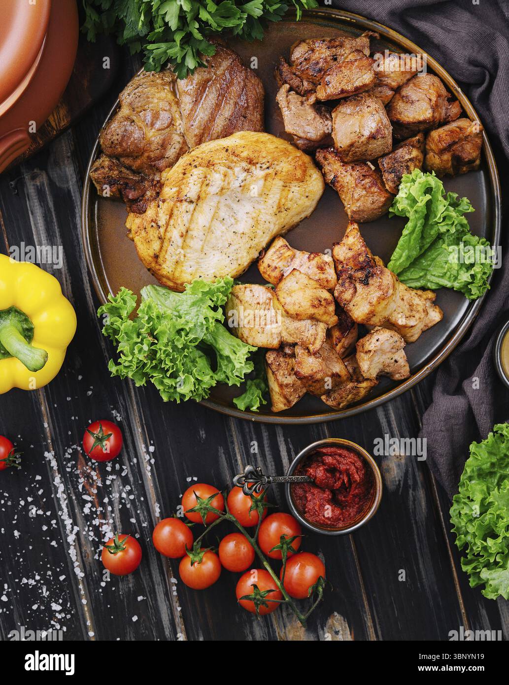 Natura morta alimentare, assortimento di carne grigliata su legno scuro Foto Stock