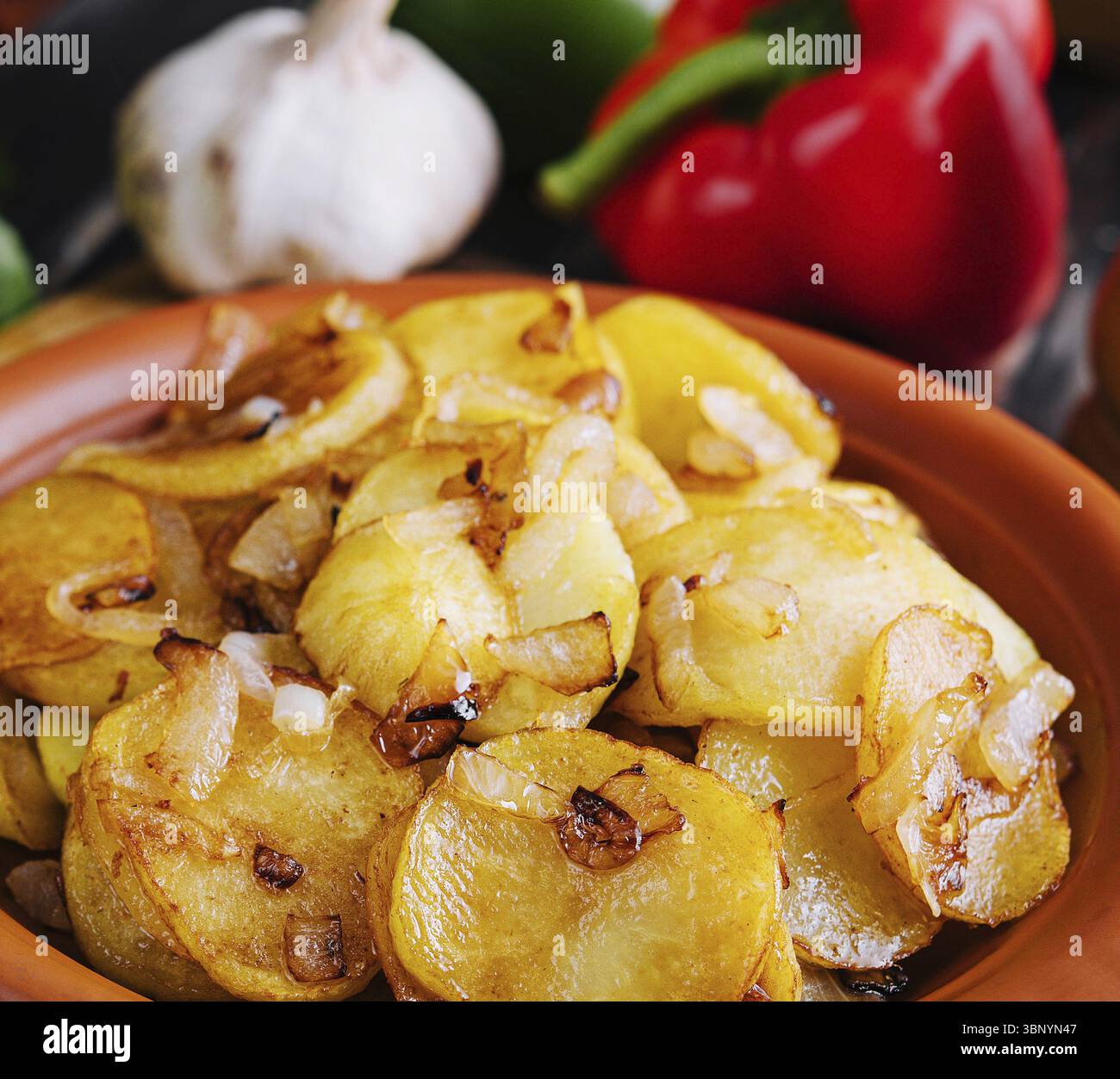 Natura morta alimentare, patate fritte con cipolle su vassoio di legno Foto Stock