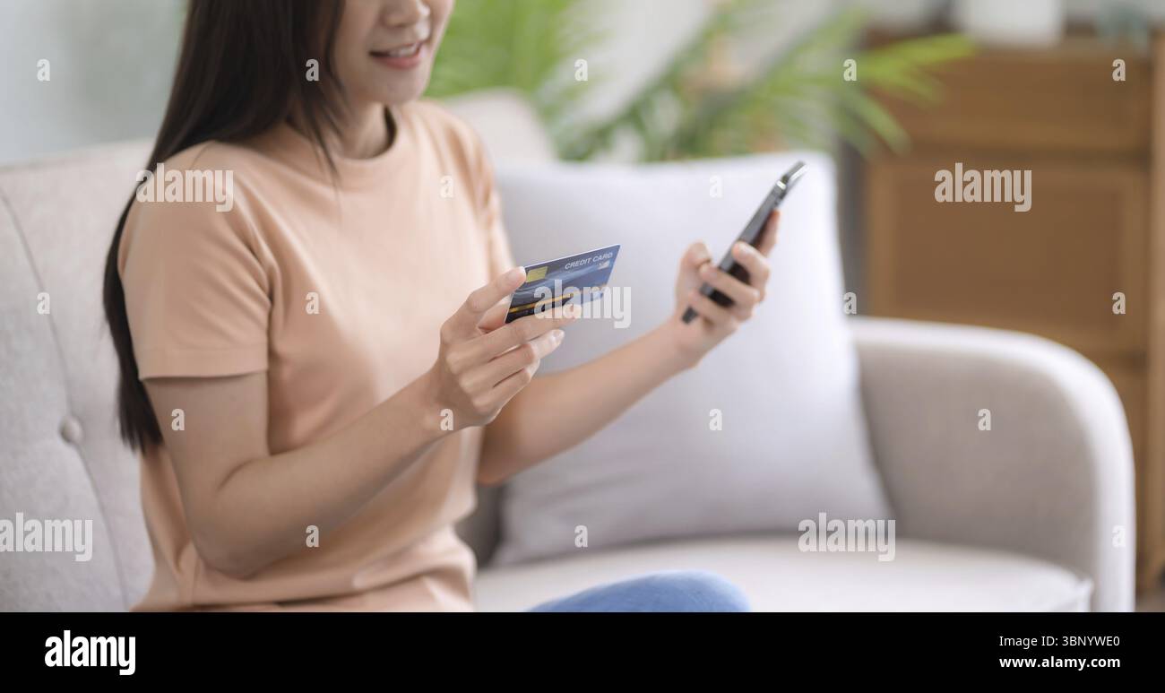 Giovane donna asiatica mano utilizzando il telefono cellulare e la carta di credito per il pagamento online, portafoglio elettronico Foto Stock