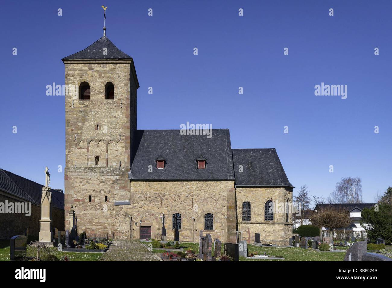 L'antica chiesa di wollersheim con la sua torre di fine XI secolo, realizzata in muratura di pietra da cava intervallata dai resti di mattoni romani Foto Stock