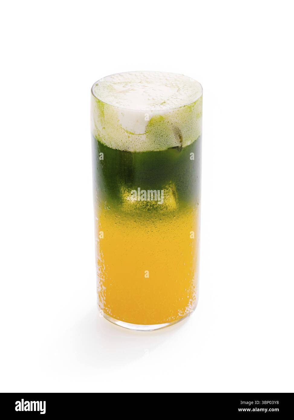 Food STILL-Life, Un alto bicchiere riempito con una bevanda visivamente attraente con strati di verde e arancione. La parte superiore schiumosa aggiunge un tocco rinfrescante, ide Foto Stock