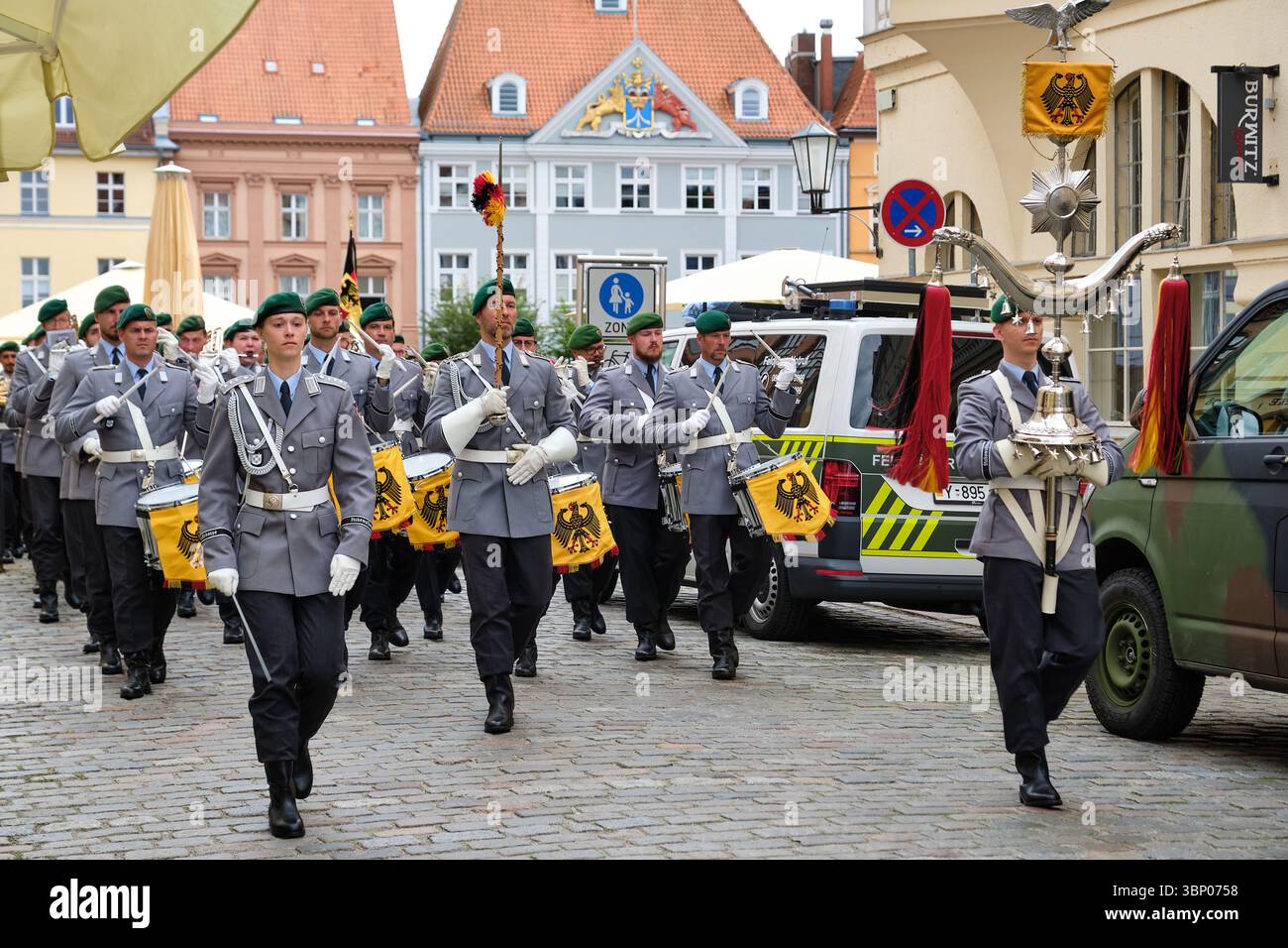 28 giugno 2025 - Stralsund-Germania: La banda militare della Bundeswehr marcia dalla vecchia piazza del mercato, conduttore femminile a sinistra, portatore standard anteriore a destra, Feldja Foto Stock