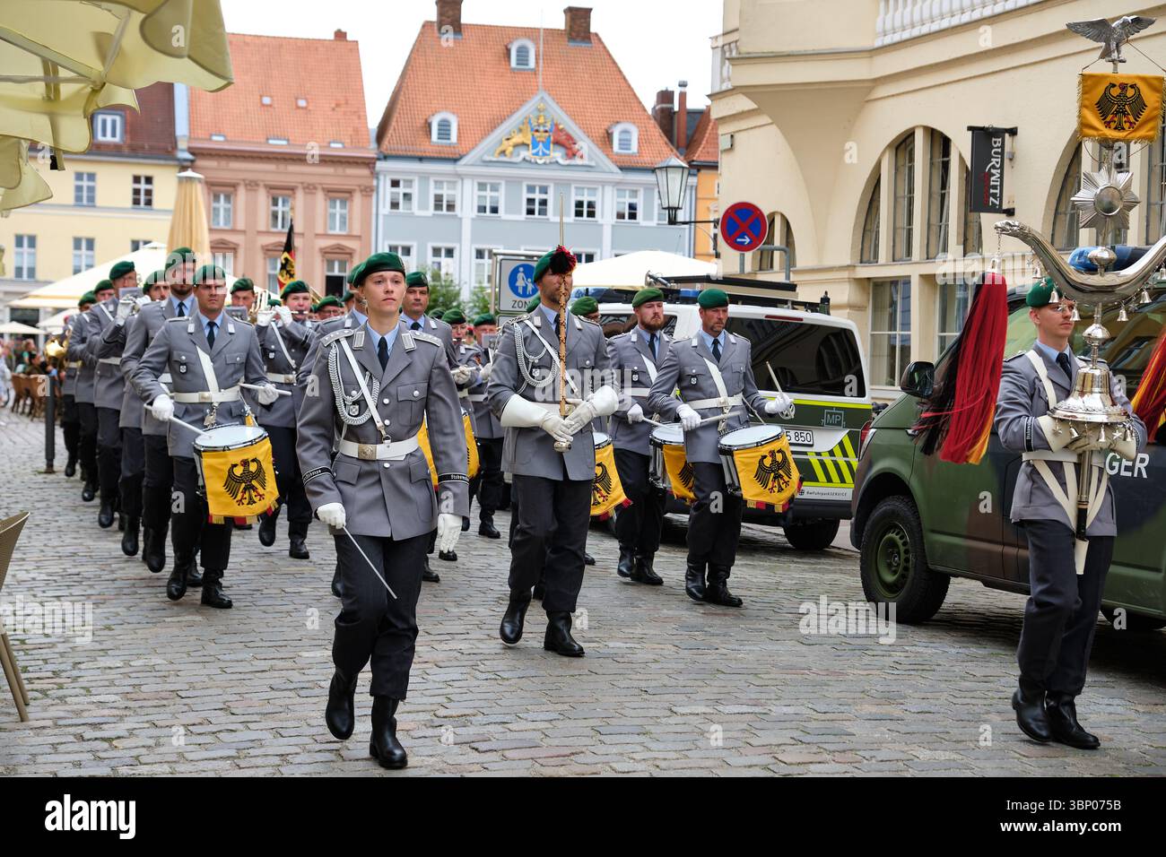 28 giugno 2025 - Stralsund-Germania: La banda militare della Bundeswehr marcia dalla vecchia piazza del mercato, conduttore femminile a sinistra, portatore standard anteriore a destra, Feldja Foto Stock