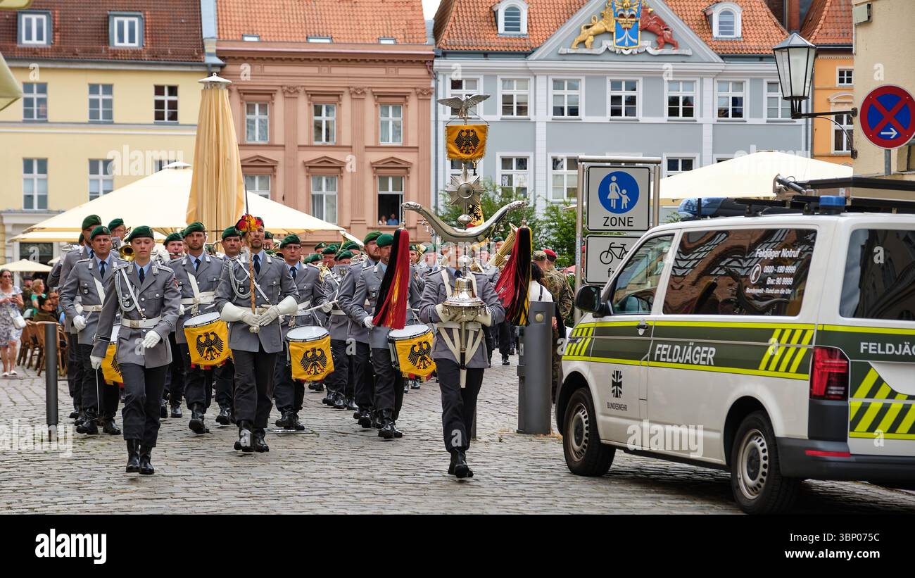 28 giugno 2025 - Stralsund-Germania: La banda militare della Bundeswehr marcia dalla vecchia piazza del mercato, conduttore femminile a sinistra, portatore standard anteriore a destra, Feldja Foto Stock