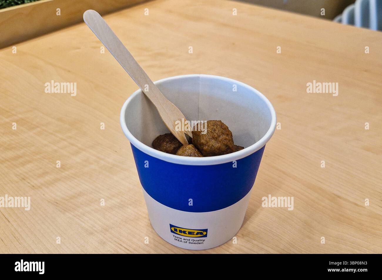 Tallinn, Estonia - 19 giugno 2025: Popolari polpette svedesi in tazza di carta con forchetta di legno presso l'area ristoro IKEA o la caffetteria. Vendita al dettaglio scandinava informale - Immagine stock catturata con smartphone