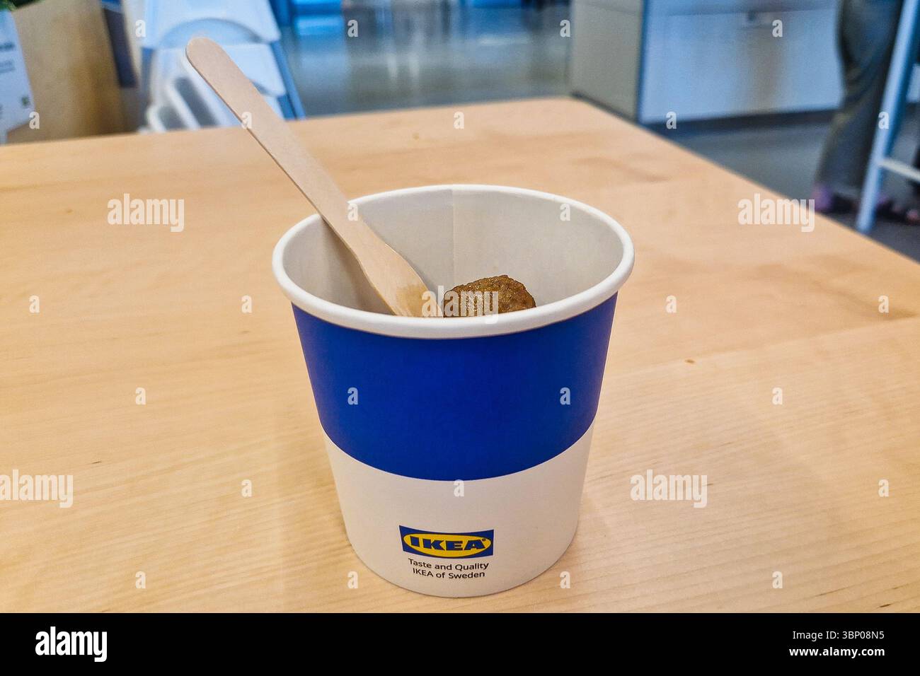 Tallinn, Estonia - 19 giugno 2025: Popolari polpette svedesi in tazza di carta con forchetta di legno presso l'area ristoro IKEA o la caffetteria. Vendita al dettaglio scandinava informale - Immagine stock catturata con smartphone