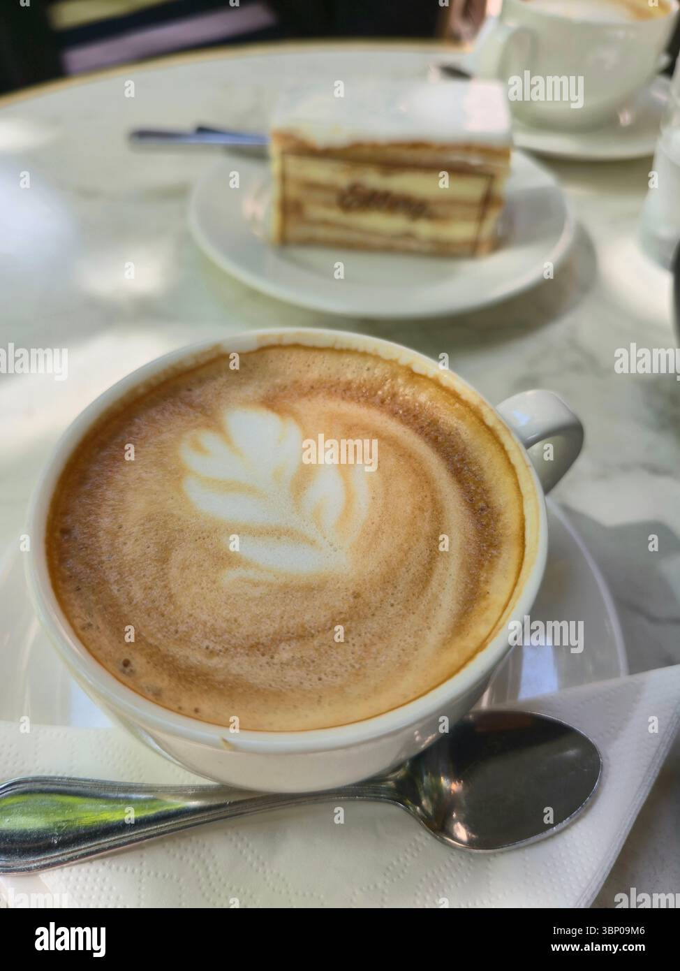 Una tazza di cappuccino e torta all'Ekberg Cafe and Restaurant di Helsinki, Finlandia. - Immagine stock catturata con smartphone