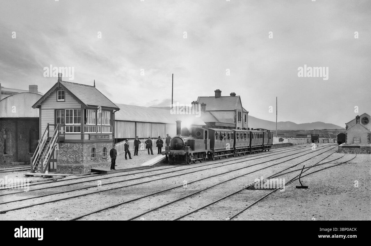 Una fotografia vintage della stazione ferroviaria di Achill all'inizio del XX secolo. Situata ad Achill Sound, serviva Achill Island nella contea di Mayo, in Irlanda, ed era il capolinea della linea che collegava Westport via Mallaranny (Mulranny) e Newport. Fu aperta dalla Midland Great Western Railway nel 1895, che fu amalgamata nella Great Southern Railway nel 1924, e chiusa nel 1937. Foto Stock