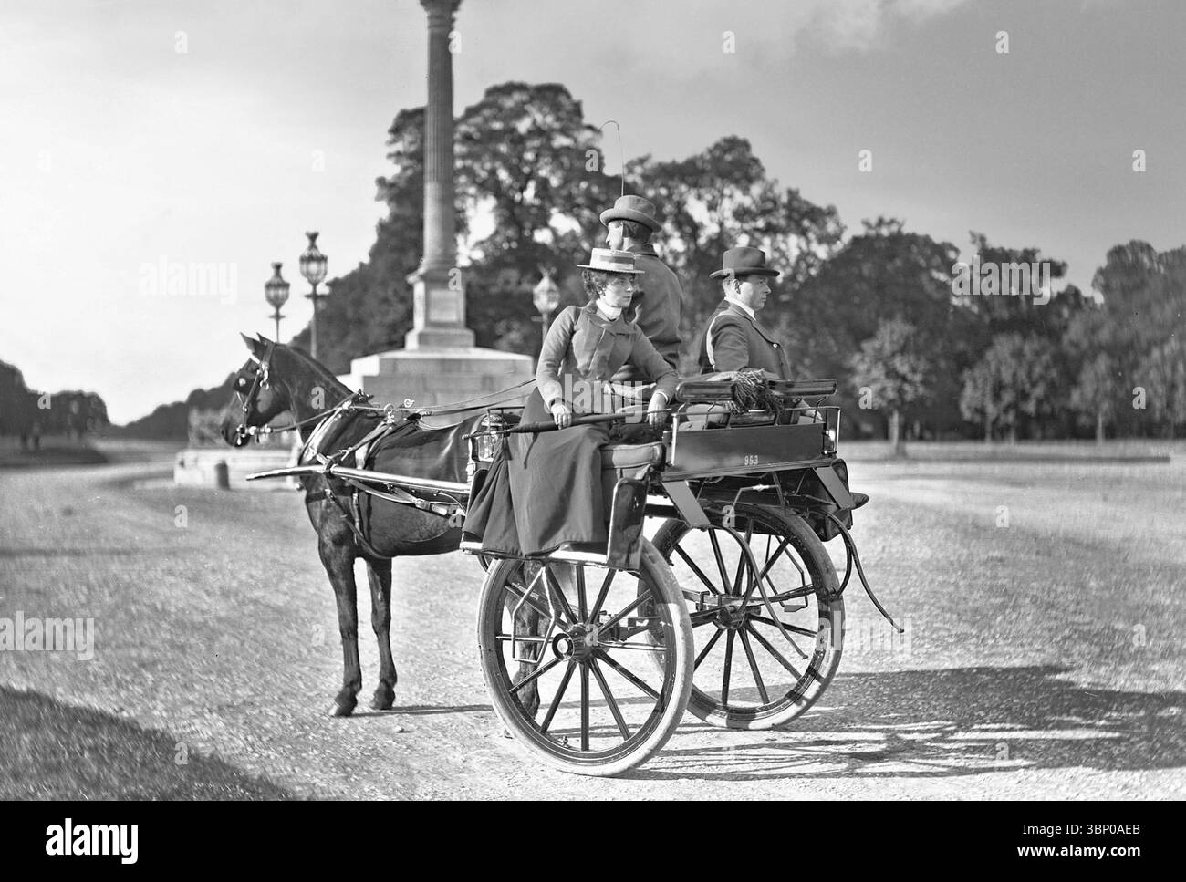 Una fotografia d'epoca di un'auto da brivido, nota anche come auto da brivido, presso la colonna Phoenix, su Chesterfield Avenue, la strada principale del Phoenix Park nella città di Dublino, Irlanda. Le auto di squalo sono carrozze leggere a due ruote con un solo cavallo, con un posto davanti per il conducente. L'auto esterna in genere può ospitare fino a quattro passeggeri seduti schiena contro schiena, con le pedane sporgenti sulle ruote. Era un tipico trasporto pubblico per le persone in Irlanda negli anni '1800, e continua ad essere utilizzato oggi come attrazione turistica. Foto Stock