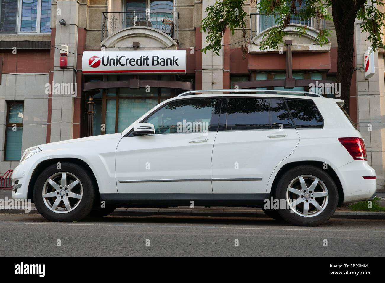 Bucarest, Romania – 22 maggio 2025: Vista laterale dell'auto bianca Mercedes GLK 220 CDI 4 MATIC parcheggiata in strada di fronte all'ufficio di UniCredit Bank Foto Stock
