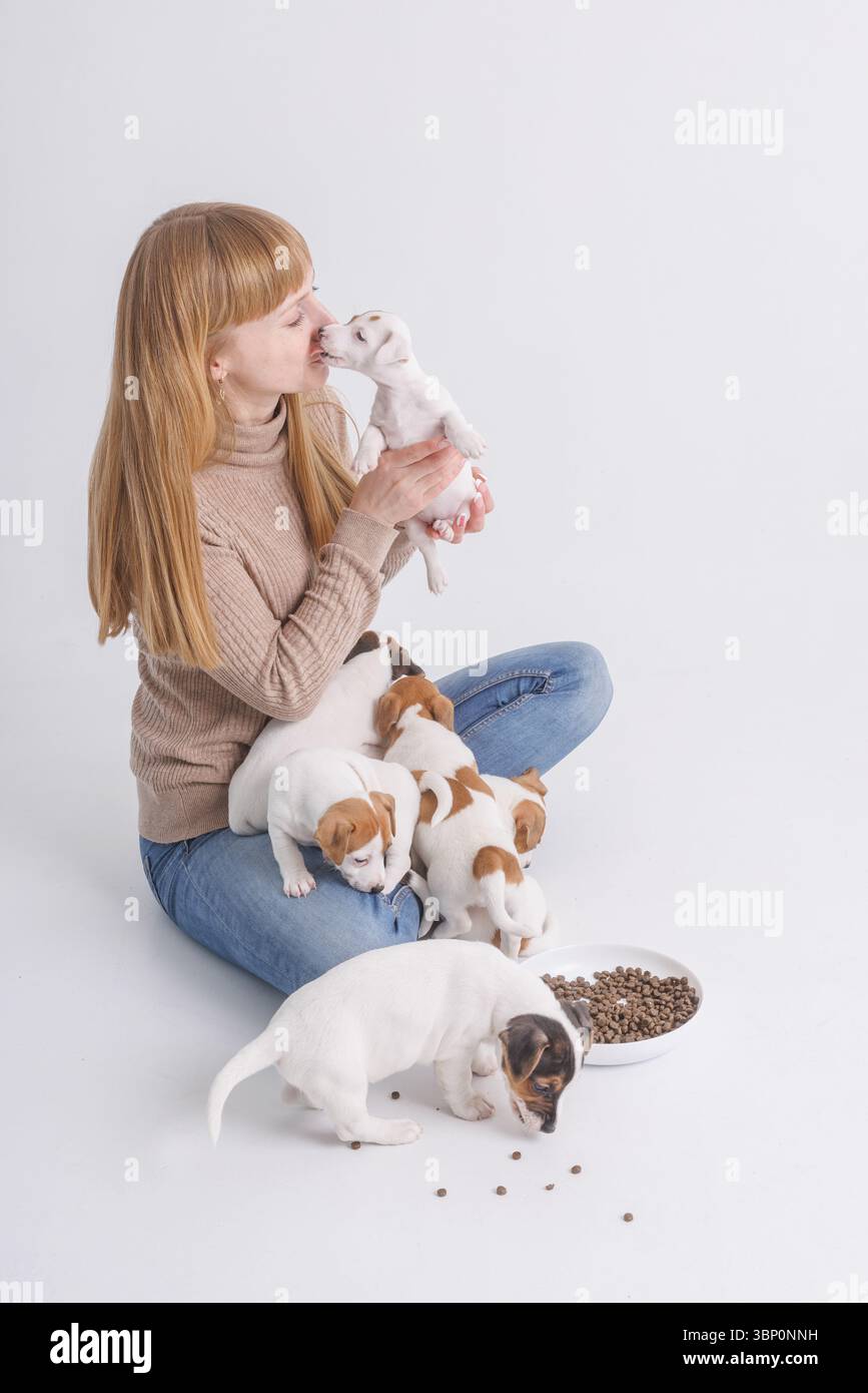 Donna con cuccioli a casa mostra amore per gli animali, cura degli animali, affetto, felicità e momenti di gioia. Foto Stock