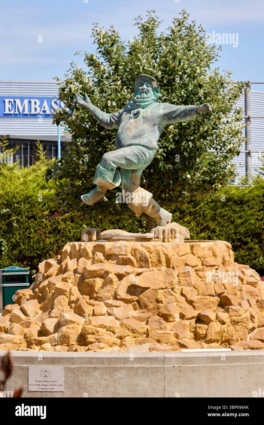 La statua del Jolly Fisherman a Skegness celebra l'iconica mascotte balneare della città, accogliendo i visitatori con la sua posa allegra e il famoso slogan Foto Stock