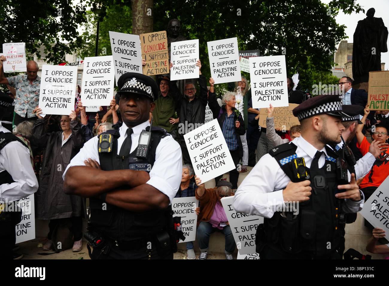 Gli agenti della polizia metropolitana osservano una protesta a sostegno dell'azione palestinese, organizzata dal gruppo DEFARD Our Juries, di fronte alla statua del Mahatma Gandhii in Parliament Square, nel centro di Londra. Data foto: Sabato 5 luglio 2025. Foto Stock