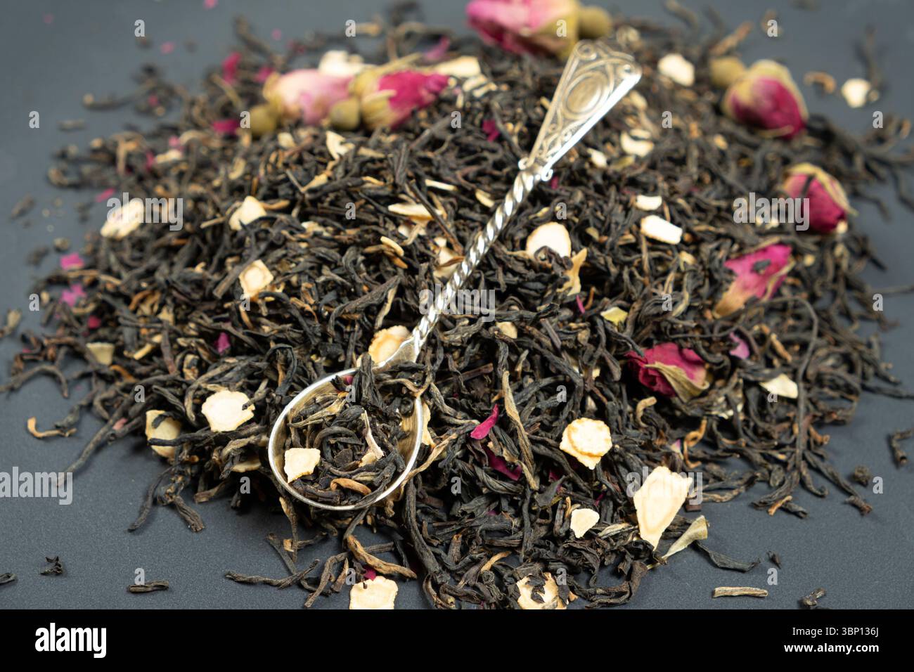 Composizione del tè nero con pezzi di ginseng e rose del tè Foto Stock