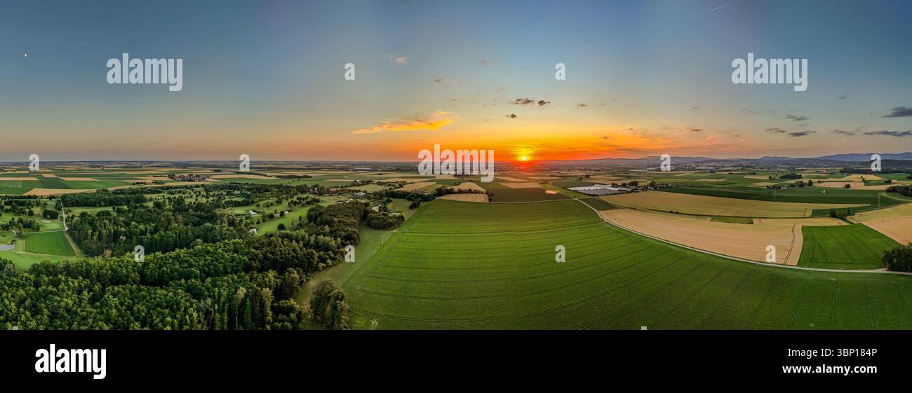Un tramonto mozzafiato colora il cielo sull'ampio paesaggio bavarese di prati, campi e foreste. La tranquillità della natura trasmette Un Foto Stock
