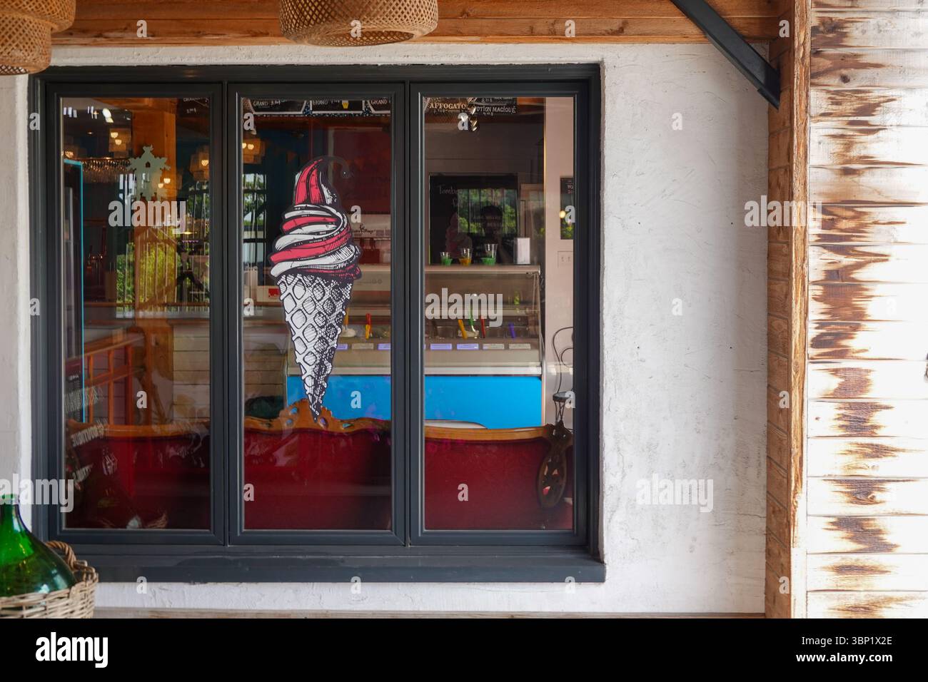 Colorata entrata della gelateria con grande decorazione a cono e vetrina Foto Stock