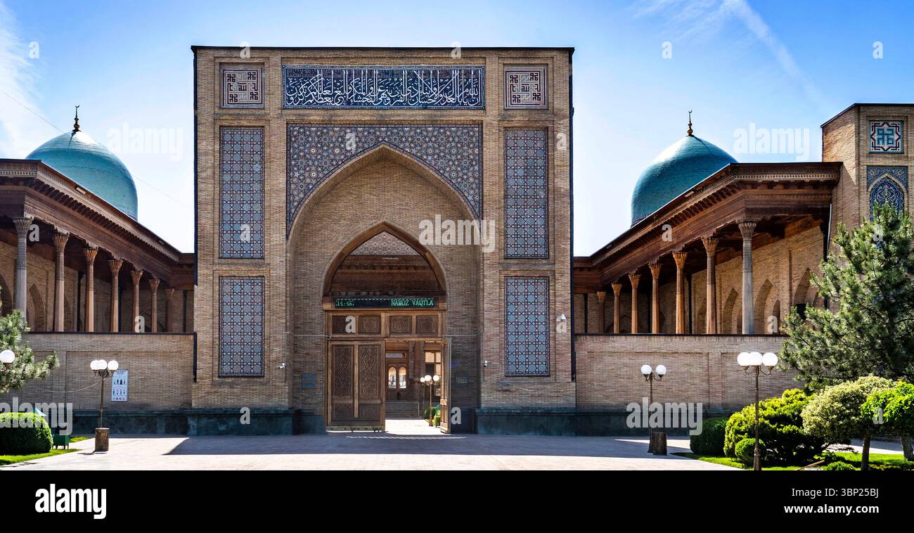 Una splendida vista architettonica di un edificio storico caratterizzato da intricate piastrelle, grande entrata ad arco e tetti a cupola. La struttura è surrogata Foto Stock