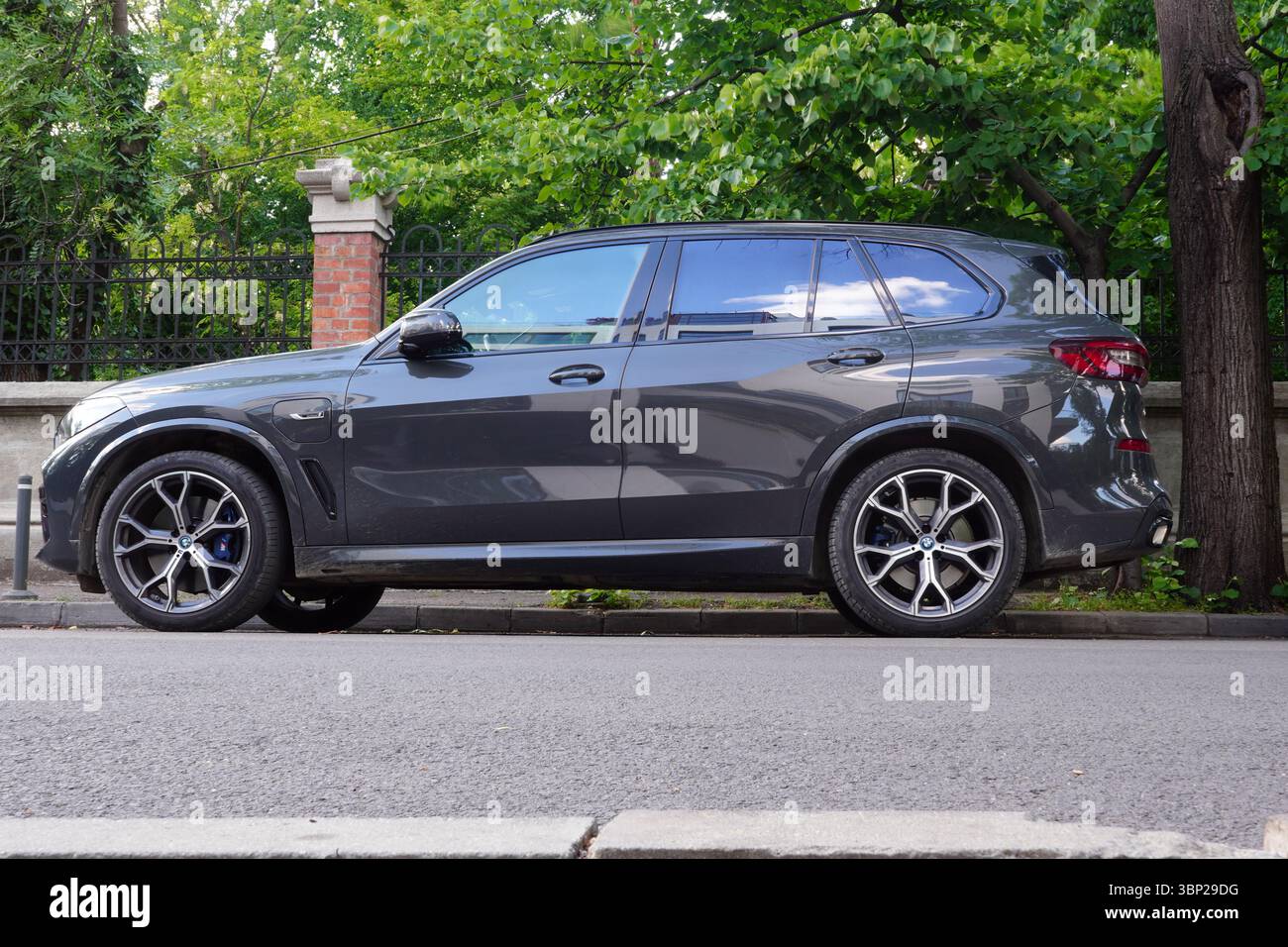 Bucarest, Romania – 11 maggio 2025: Vista ravvicinata della BMW X5 xDrive 45e parcheggiata sulla strada lungo la recinzione del giardino Foto Stock
