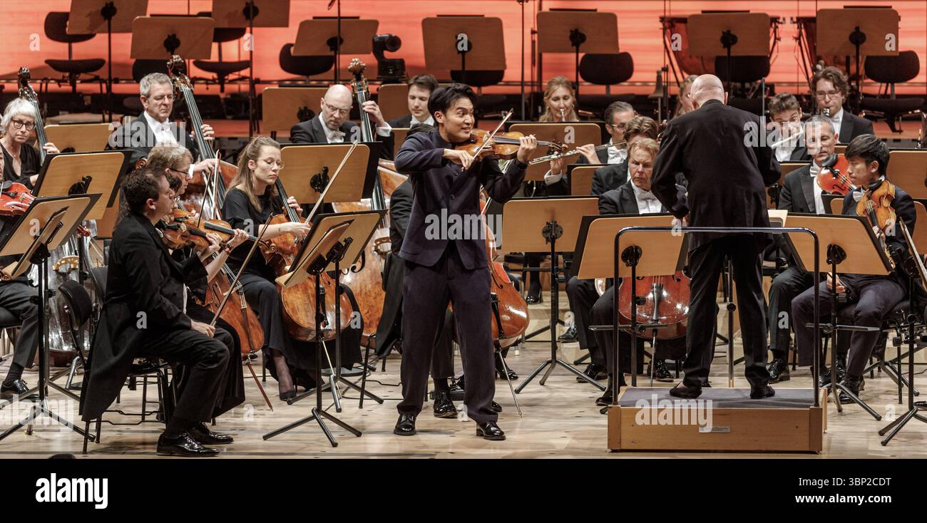 05 luglio 2025, Schleswig-Holstein, Lübeck: Il violinista taiwanese-australiano Ray Chen (M) suona con la NDR Elbphilharmonie Orchester sotto la direzione di Christoph Eschenbach (r) al concerto di apertura dello Schleswig-Holstein Musik Festival 2025. Foto: Markus Scholz/dpa Foto Stock