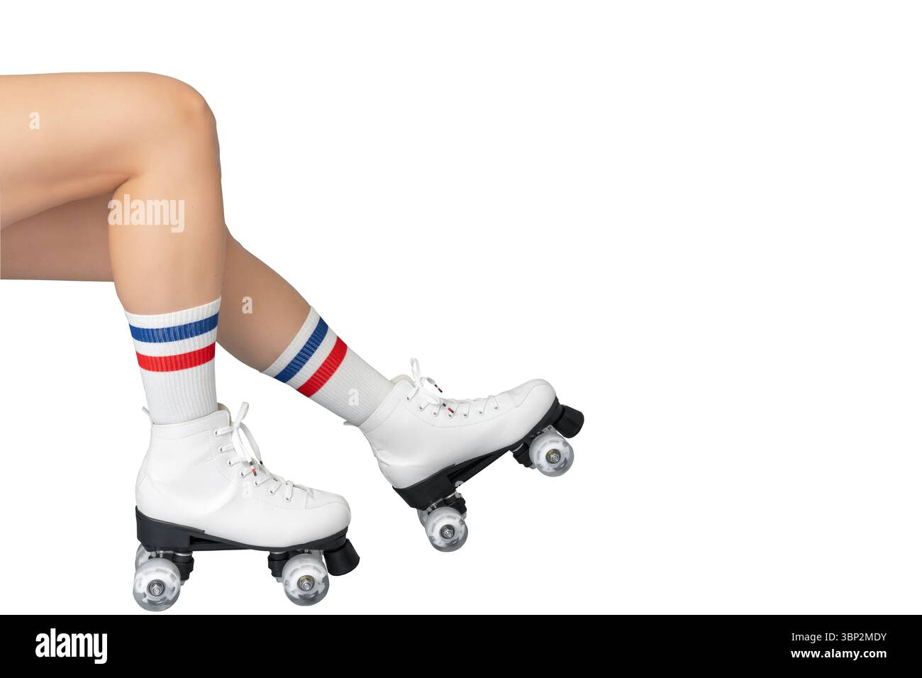 Primo piano di gambe femminili caucasiche adulte con pattini bianchi con calzini a righe Foto Stock