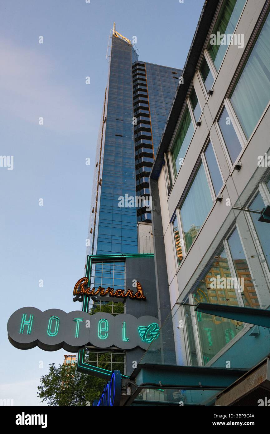 L'insegna al neon del Burrard Hotel lungo Burrard Street con una torre Wall Centre dietro, nel centro di Vancouver, BC. Foto Stock