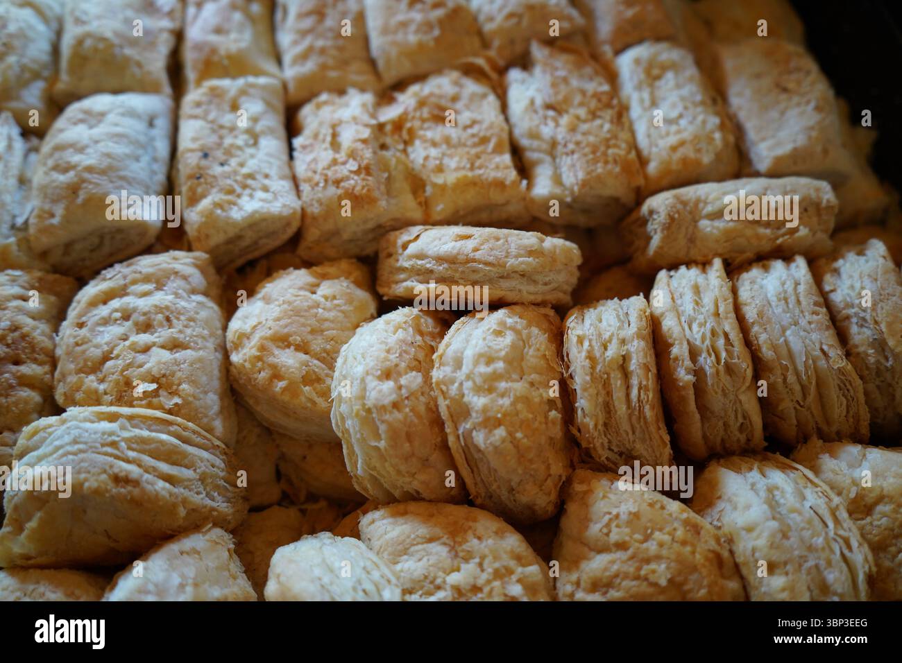 Un'immagine ravvicinata di sfoglia ripiena di formaggio appena sfornata. Marrone dorato, friabile e croccante, i dolci sono ben disposti. Foto Stock