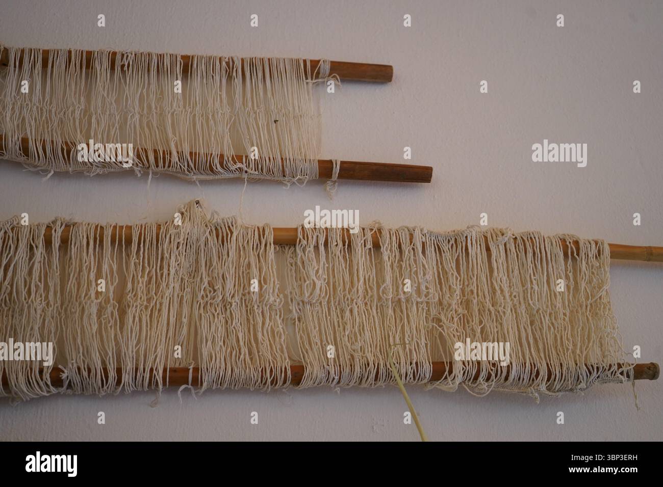 Preparazione tradizionale del filato cretese con aste in legno e filo bianco naturale, utilizzata nei telai per tessitura per l'organizzazione della curvatura. Foto Stock