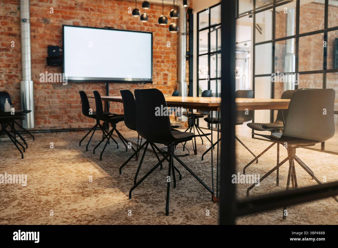 Sedie disposte intorno al tavolo nella sala meeting dell'ufficio Foto Stock