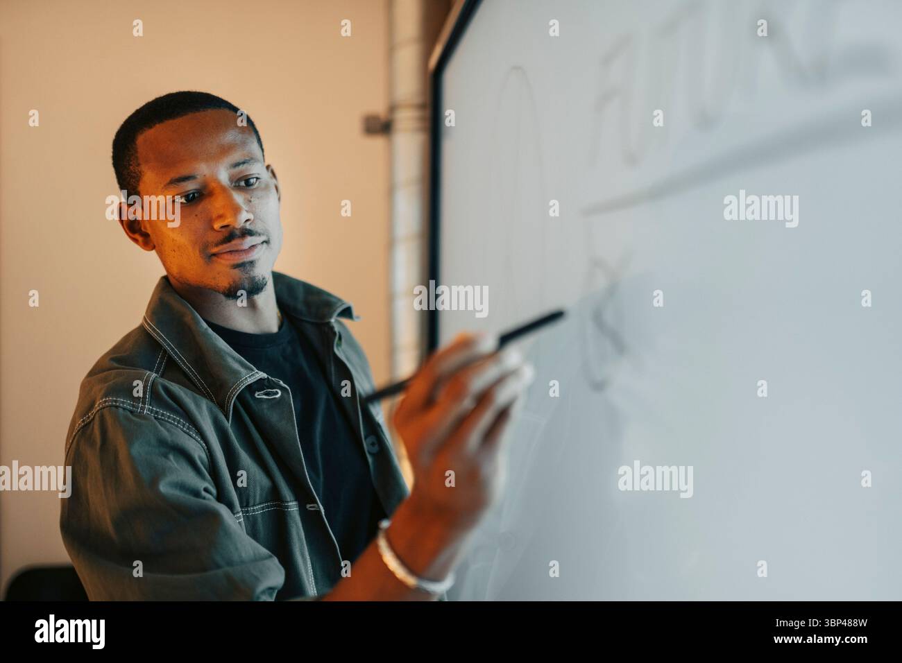 Imprenditore maschile che scrive idee sullo schermo con penna digitalizzata nella sala riunioni Foto Stock