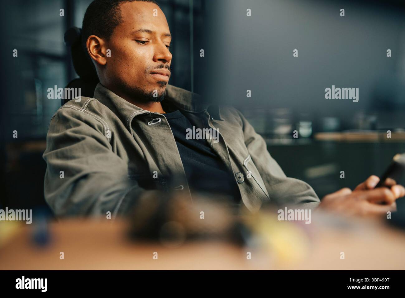 Uomo d'affari che usa lo smartphone in ufficio Foto Stock