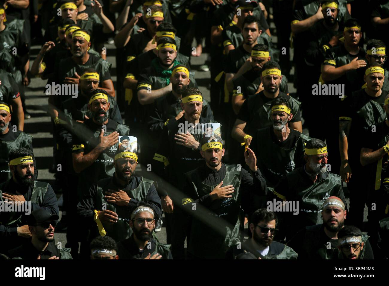 Beirut, Libano. 6 luglio 2025. I lutti sciiti adornati con immagini del loro leader assassinato Hassan Nasrallah, in una manifestazione di massa che commemora Ashoura, si impegnano in un rituale di picchiata sul petto per celebrare l'uccisione del nipote del profeta Maometto, Hussein. Questa espressione distintiva di dolore, unica nella tradizione sciita, si trova in contrasto con le pratiche sunnite, che evitano tali atti di auto-flagellazione, picchiando e coprendosi nel fango, citando l'ingiunzione del Profeta Maometto contro la degradazione del corpo umano. Crediti: Marwan Naamani/dpa/Alamy Live News Foto Stock