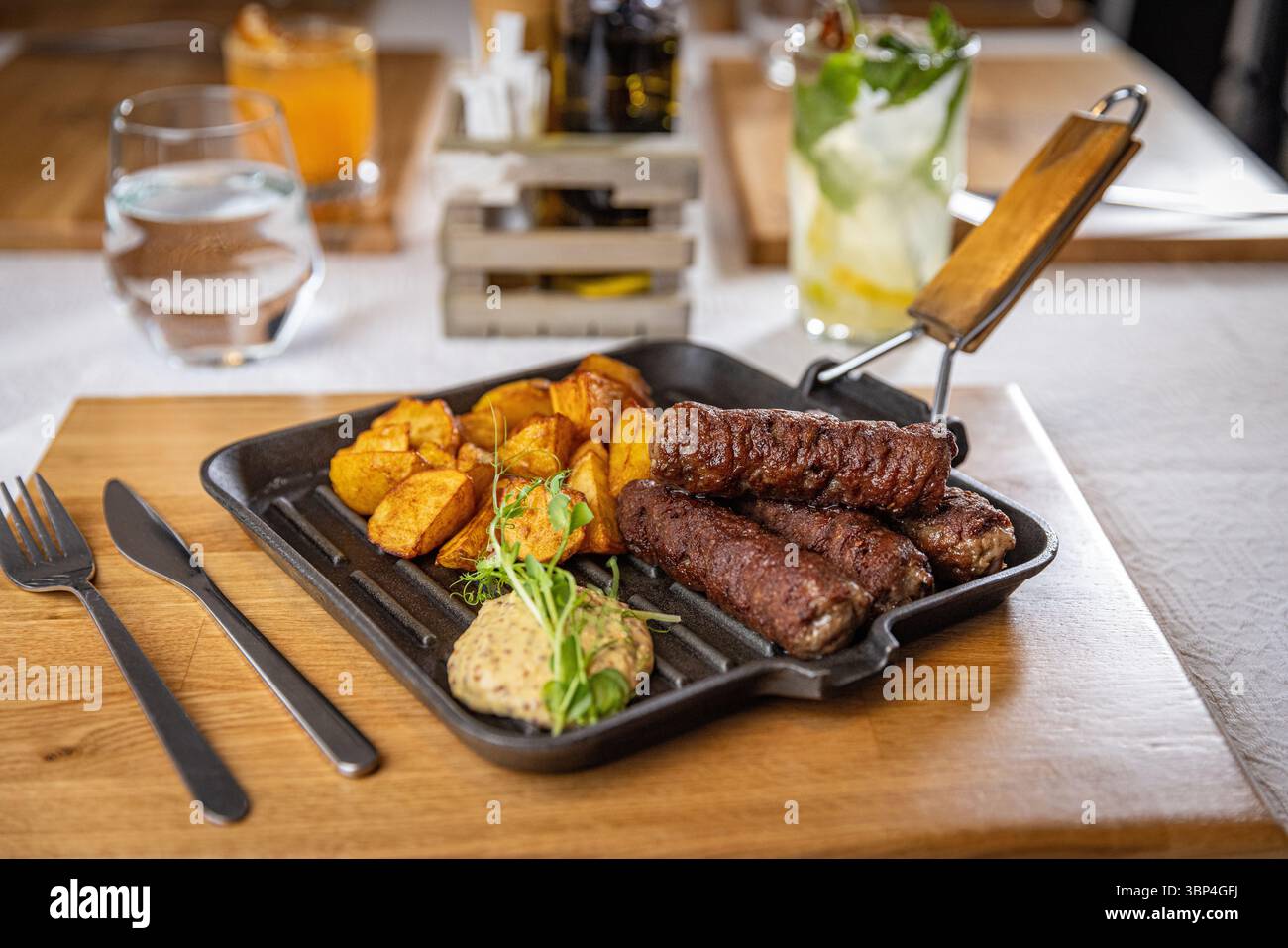 mici rumeni, salsicce tradizionali senza pelle, servite con patate arrosto e senape, ambiente ristorante Foto Stock