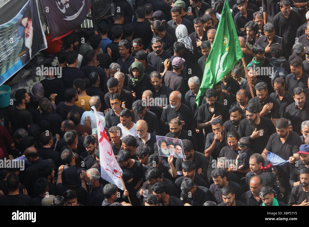 I lori musulmani sciiti del Kashmir prendono parte ad una processione Muharram il decimo giorno di Ashura a Srinagar il 6 luglio 2025, segnando il martirio dell'Imam Hussain con rituali che battono il petto e striscioni in devozione. Foto Stock