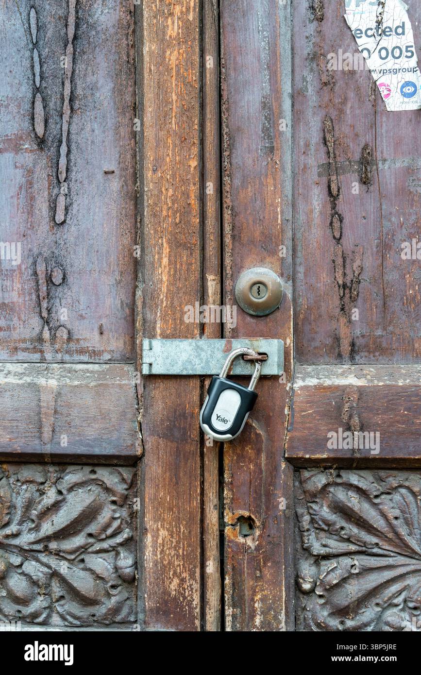 Lucchetto che fissa le vecchie porte in legno Foto Stock