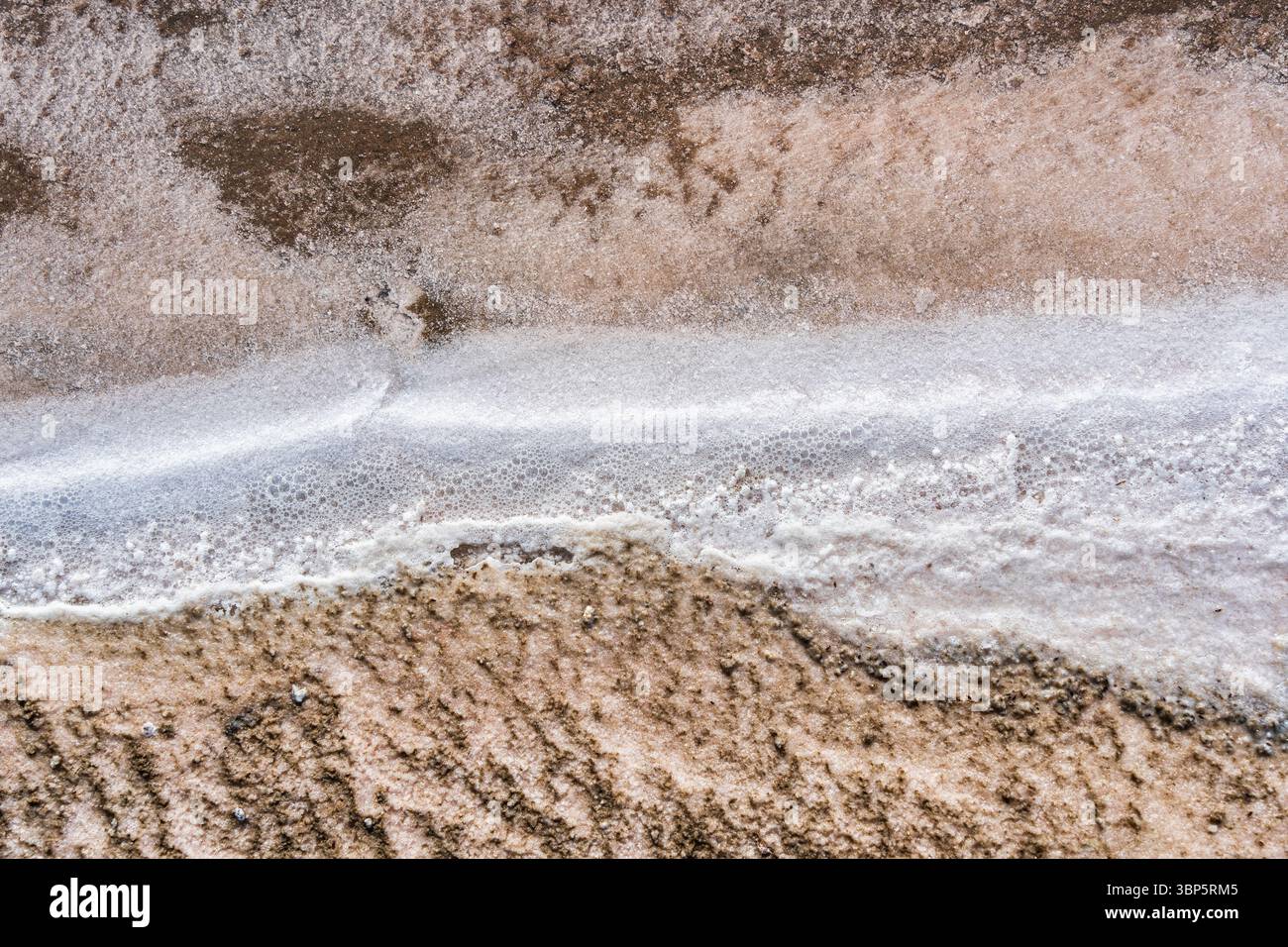 Formazioni di crosta salata lungo il bordo della laguna salata rosa nella riserva nazionale di Paracas, Perù. Sfondo con trama astratta e naturale. Foto Stock