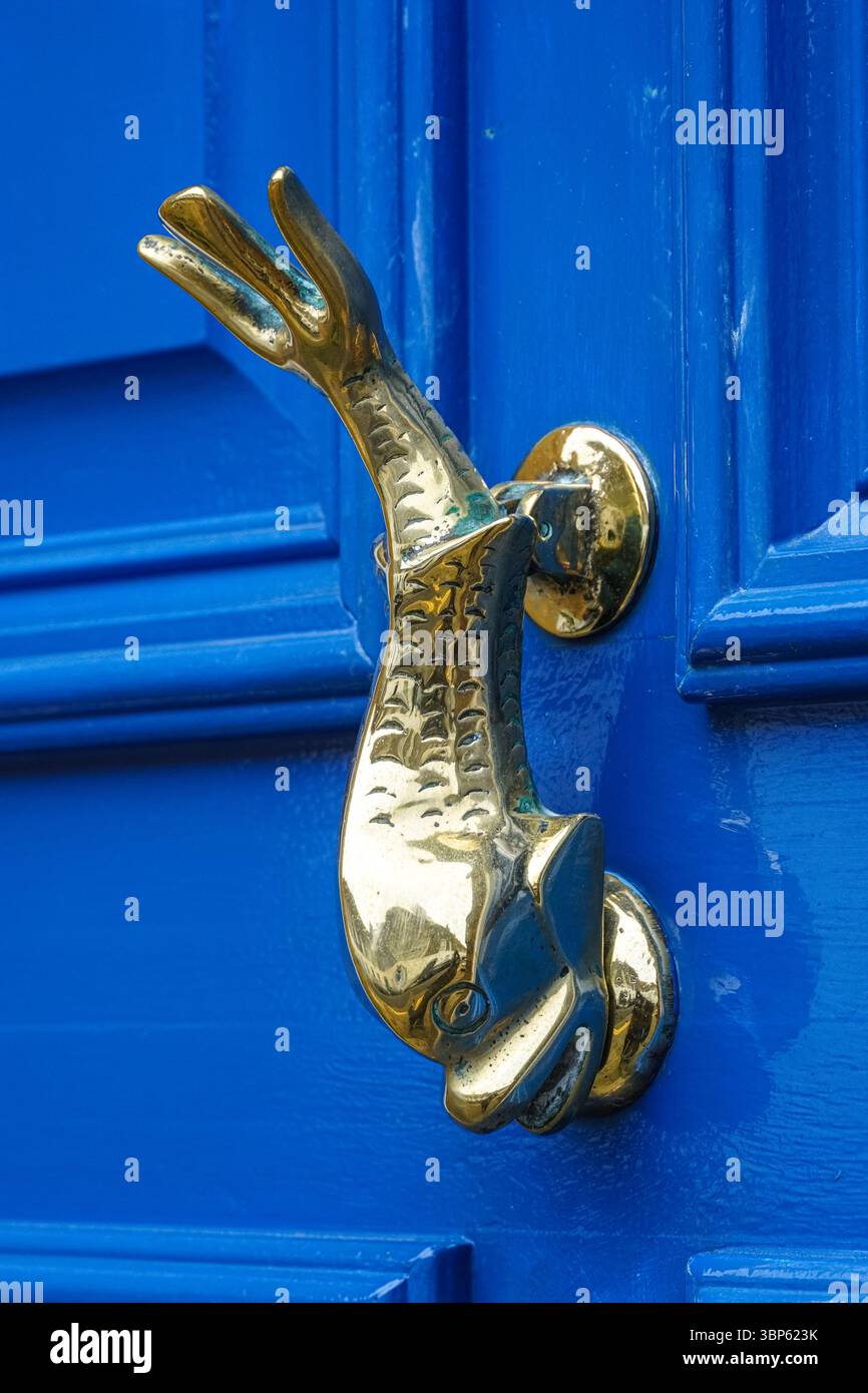 Porta in ottone a forma di pesce bussa su una porta blu, Londra Inghilterra Regno Unito Regno Unito Foto Stock