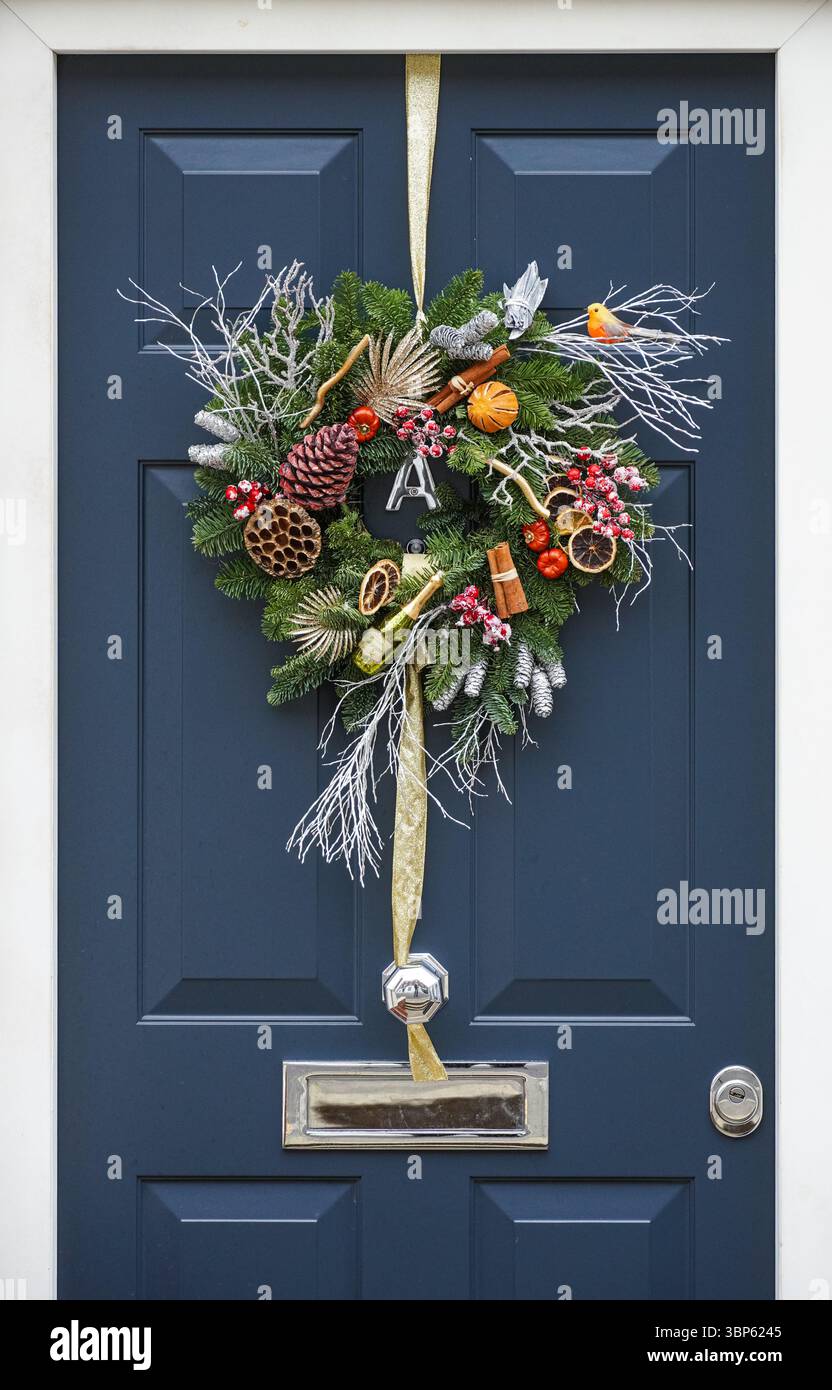 La corona decorativa di Natale è appesa su una porta d'ingresso di una casa a Kensington, Londra, Inghilterra, Regno Unito, Regno Unito Foto Stock