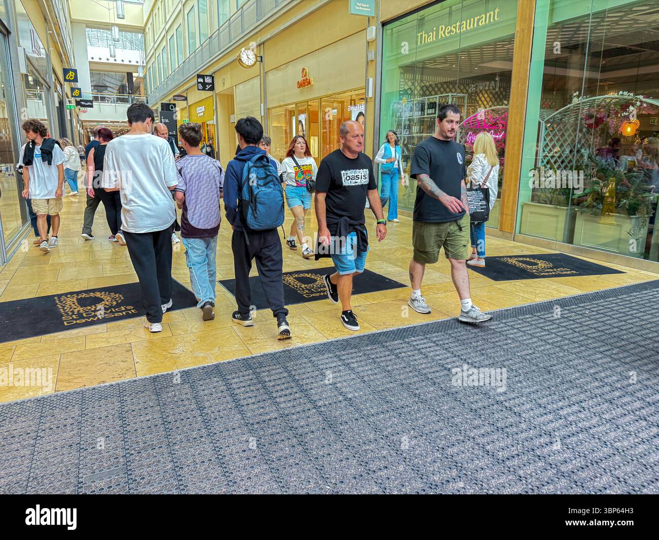 Oasis Reunion Live '25 Tour Cardiff Concert fans indossando T-shirt e Merchandise Band nel centro commerciale Stant Davids Foto Stock