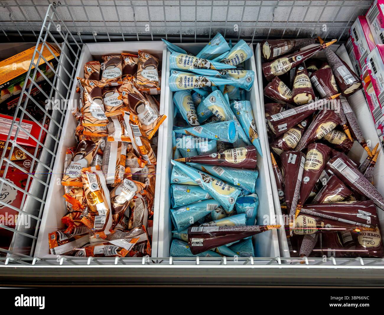 Italia - 06 luglio 2025: Gelato e coni da gelato cornetto in vista dall'alto nel bancone refrigerato del supermercato italiano Foto Stock