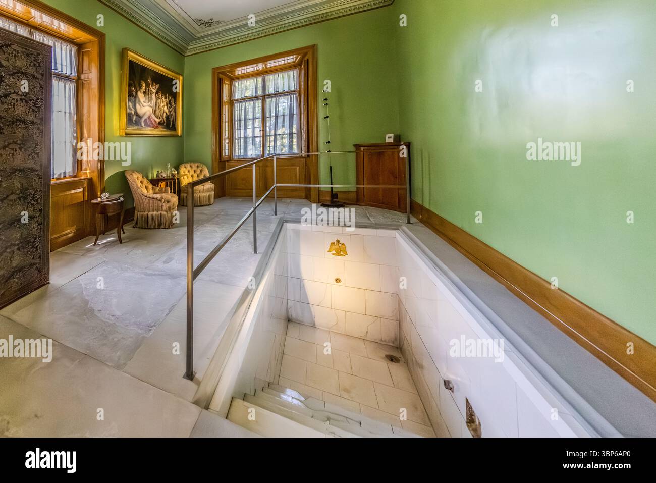 Il bagno storico del castello di Arenenberg a Salenstein, nel Canton Turgovia, in Svizzera, è dotato di pareti dipinte di verde, una vasca da bagno incassata e poltrone imbottite. Un dipinto classico è appeso alla parete e finestre con cornici in legno lasciano entrare la luce del giorno. Foto Stock