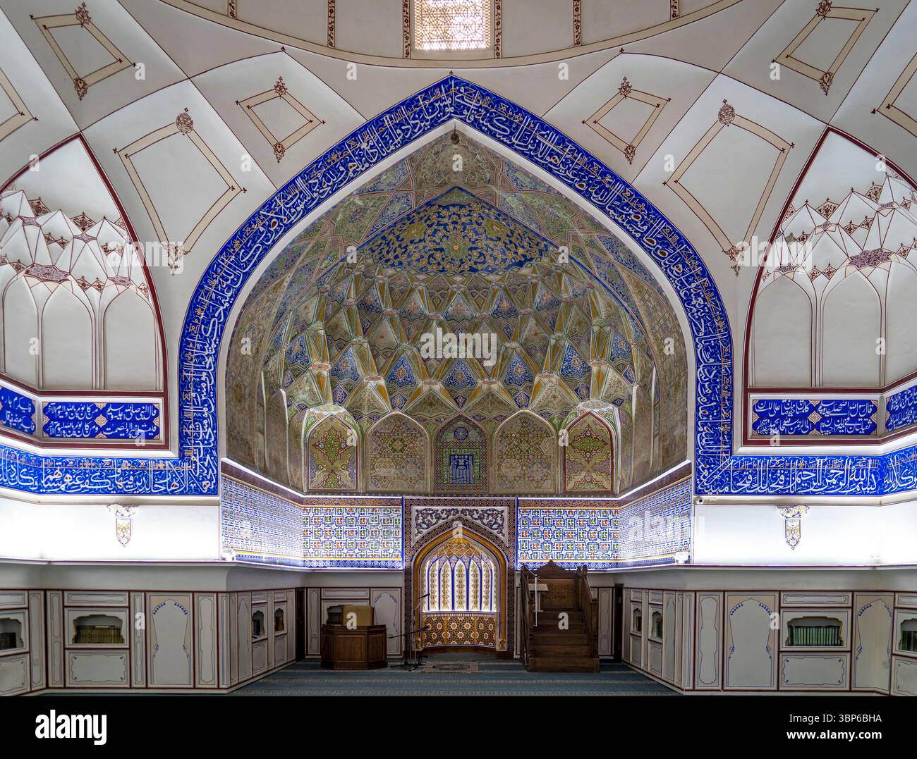 Un interno ornato di una moschea caratterizzato da intricati lavori di piastrelle, calligrafia e una cupola splendidamente progettata. I colori vivaci e i motivi creano una S. Foto Stock