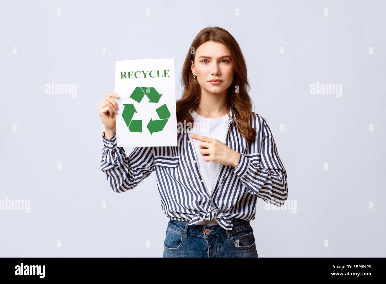 Donna che promuove pratiche di riciclaggio ecocompatibili in un ambiente minimalista Foto Stock