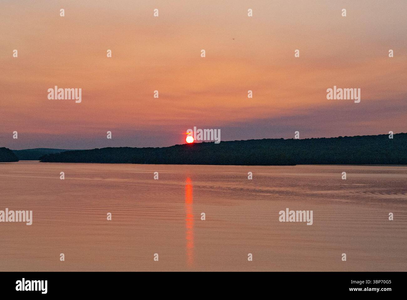 Un tramonto arancione di colore profondo in un lago dell'Ontario, Canada. Foto Stock