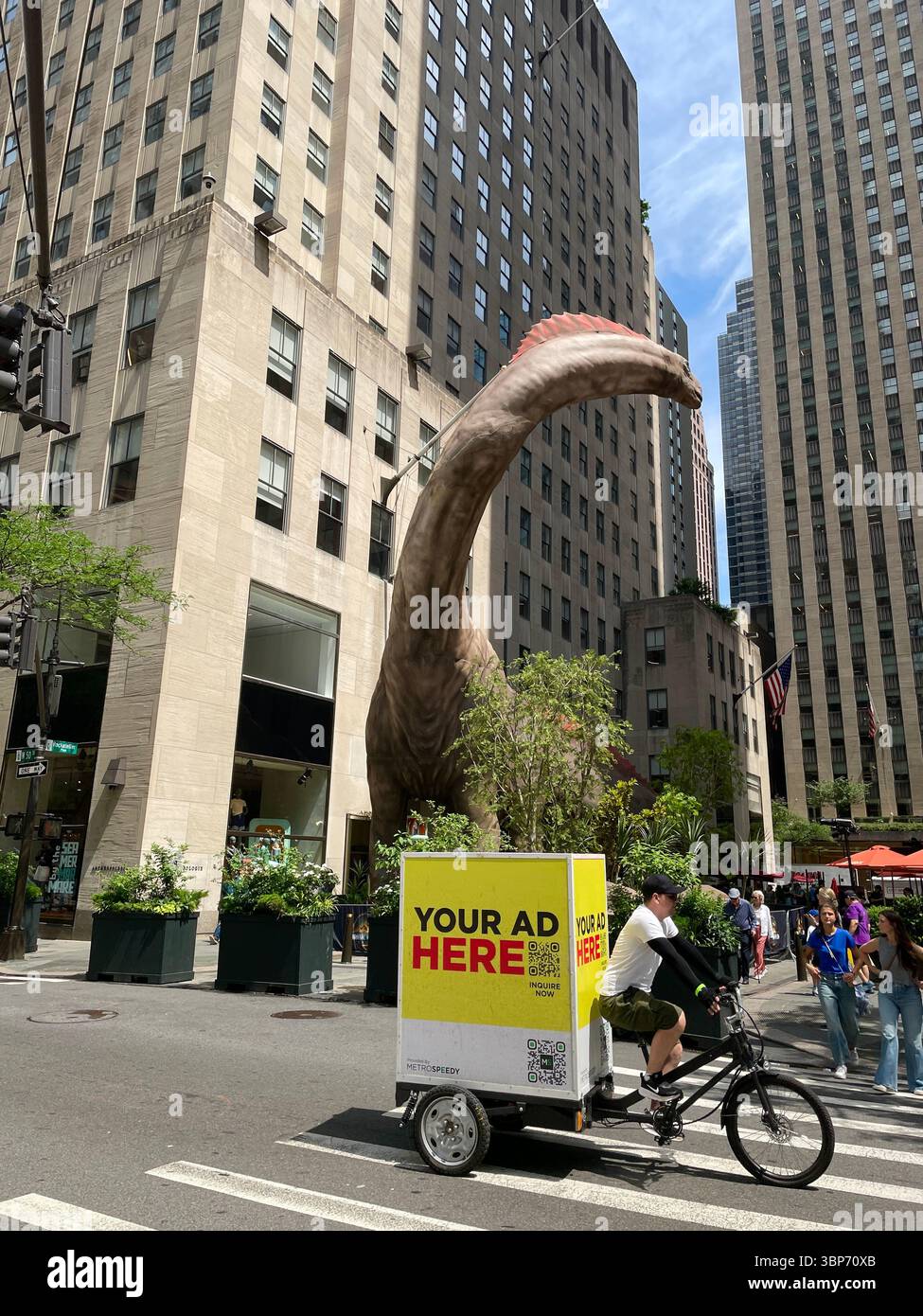 Una promozione "Jurassic World Rebirth" nel Rockefeller Center presenta un dinosauro alto cinque piani, 2025, New York City, USA - Immagine stock catturata con smartphone